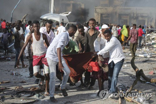 지난 14일 발생한 소말리아 수도 모가디슈 폭탄테러 현장에서 사람들이 희생자를 옮기는 모습 [EPA/SAID YUSUF WARSAME=연합뉴스]